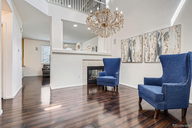 1179 S Fultondale Cir, Aurora, CO 80018 - living area featuring a high ceiling, wood finished floors, a chandelier, baseboards, and a tiled fireplace