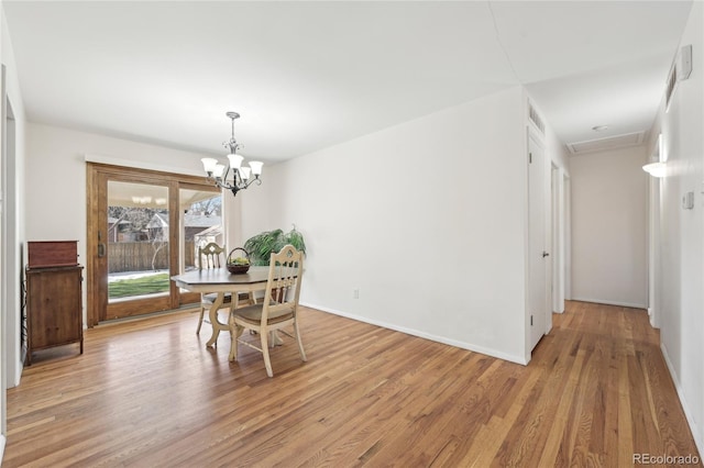 dining space featuring light hardwood / wood-style flooring and a notable chandelier