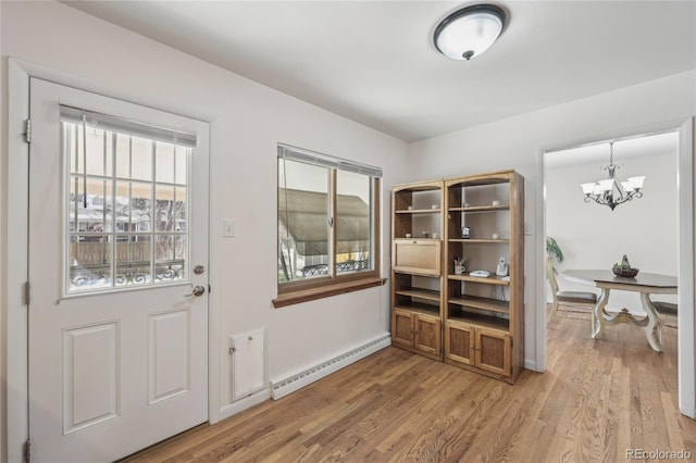 doorway with a baseboard radiator, wood-type flooring, and a chandelier