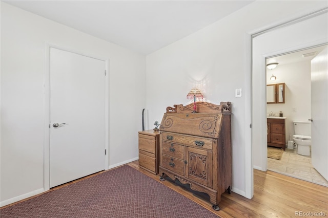 bedroom featuring wood-type flooring and connected bathroom