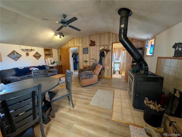 2117 Badger Creek Rd, Hartsel, CO 80449 - dining area featuring a wood stove, vaulted ceiling, light wood-type flooring, ceiling fan, and wood walls