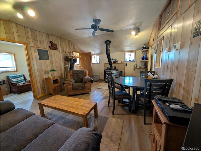 2117 Badger Creek Rd, Hartsel, CO 80449 - living room with a wood stove, wooden walls, vaulted ceiling, a ceiling fan, and light wood finished floors