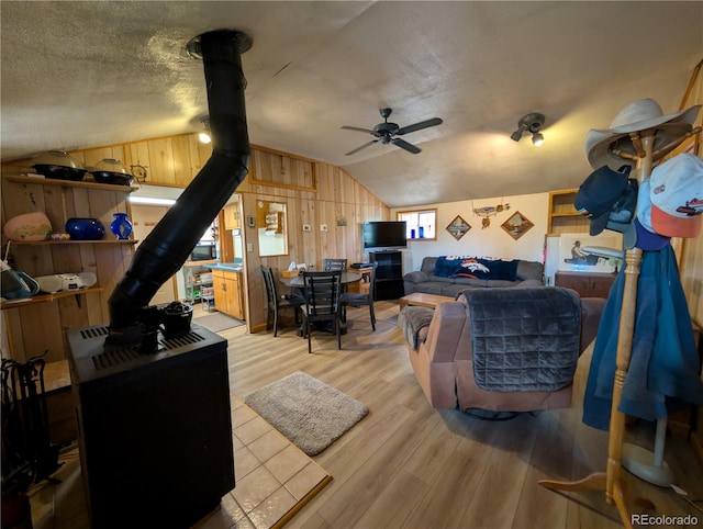 2117 Badger Creek Rd, Hartsel, CO 80449 - living area featuring a wood stove, lofted ceiling, light wood-style floors, ceiling fan, and wooden walls