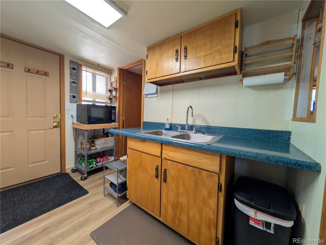 2117 Badger Creek Rd, Hartsel, CO 80449 - kitchen featuring black microwave, light wood-style flooring, dark countertops, and brown cabinetry