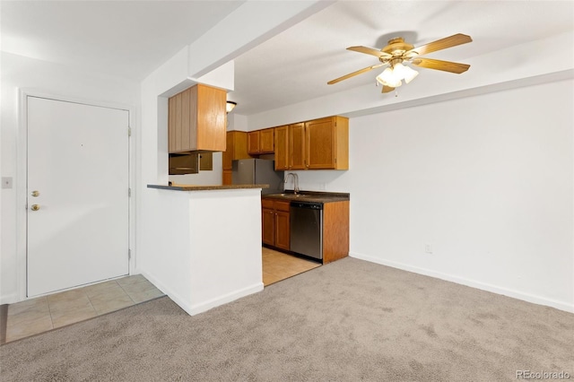 kitchen with light carpet, appliances with stainless steel finishes, dark countertops, and a sink