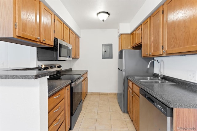 kitchen with light tile patterned floors, a sink, appliances with stainless steel finishes, electric panel, and dark countertops