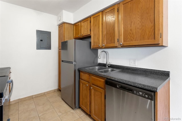 kitchen with electric panel, brown cabinetry, dark countertops, stainless steel appliances, and a sink