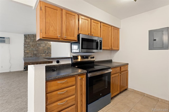 kitchen with a wall unit AC, stainless steel appliances, electric panel, brown cabinetry, and dark countertops