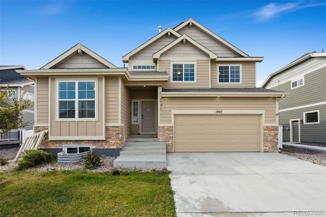 craftsman-style home with stone siding, concrete driveway, a garage, and a front yard