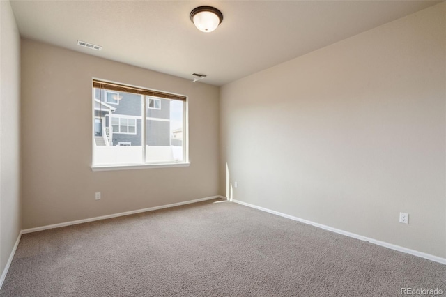 carpeted spare room featuring baseboards
