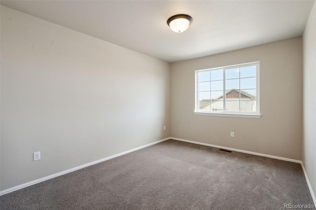empty room featuring carpet floors and baseboards