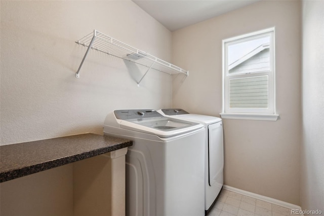 laundry area with washing machine and clothes dryer and baseboards
