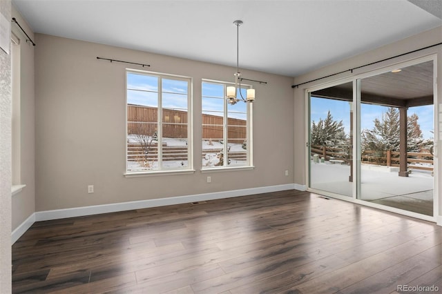 unfurnished dining area featuring a chandelier and dark hardwood / wood-style floors