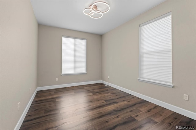 unfurnished room with dark hardwood / wood-style flooring