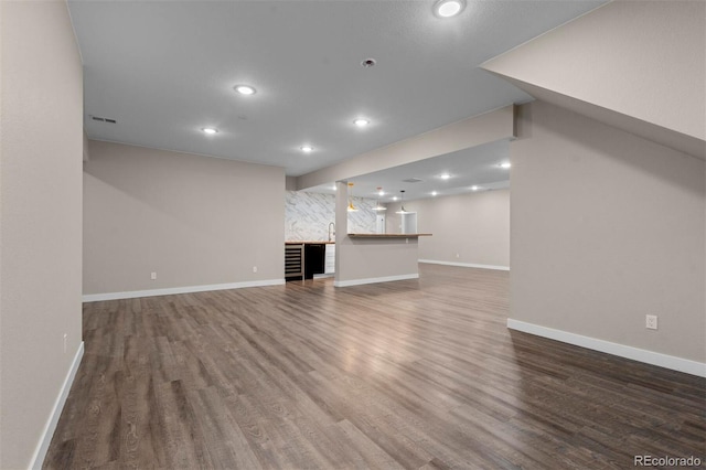 unfurnished living room with sink and dark wood-type flooring