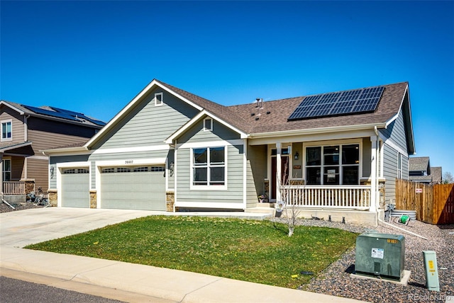 56607 E 23rd Ave, Strasburg, CO 80136 - view of front of property with roof mounted solar panels, a garage, a front lawn, concrete driveway, and a porch