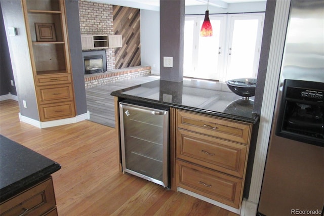 12381 E Vassar Dr, Aurora, CO 80014 - kitchen with stainless steel refrigerator with ice dispenser, beverage cooler, light wood-type flooring, and a fireplace
