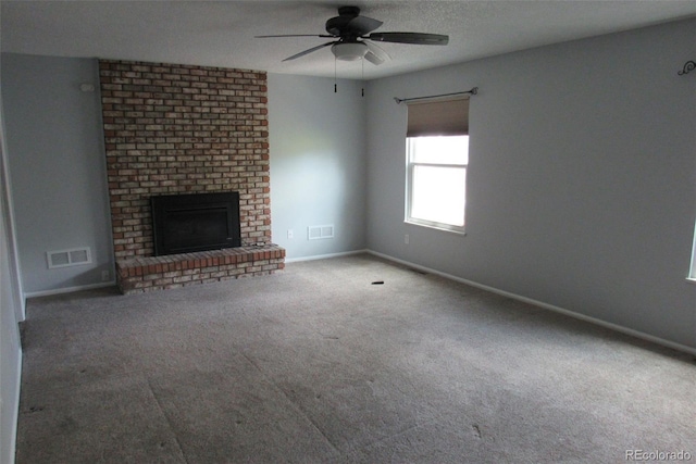 12381 E Vassar Dr, Aurora, CO 80014 - unfurnished living room featuring carpet floors, a ceiling fan, a brick fireplace, and baseboards