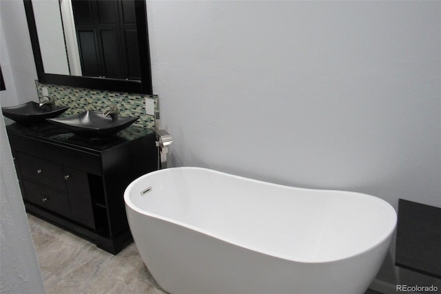 12381 E Vassar Dr, Aurora, CO 80014 - full bathroom with tasteful backsplash, a freestanding tub, and double vanity