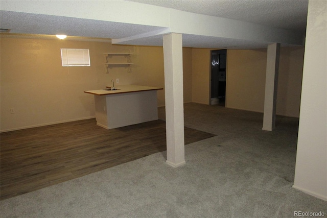 12381 E Vassar Dr, Aurora, CO 80014 - finished below grade area featuring a textured ceiling, carpet floors, wood finished floors, and baseboards
