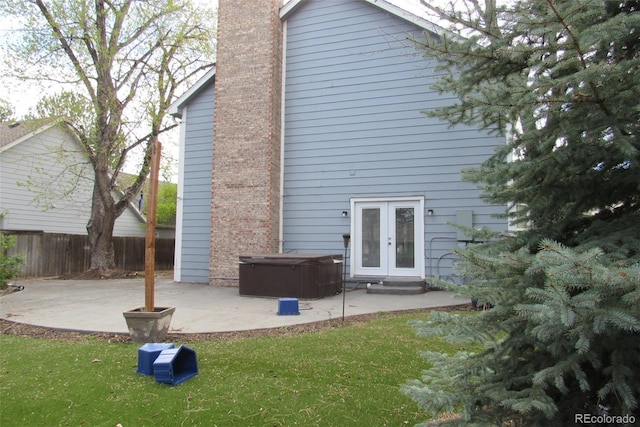 12381 E Vassar Dr, Aurora, CO 80014 - rear view of property featuring a patio area, a hot tub, french doors, and a chimney