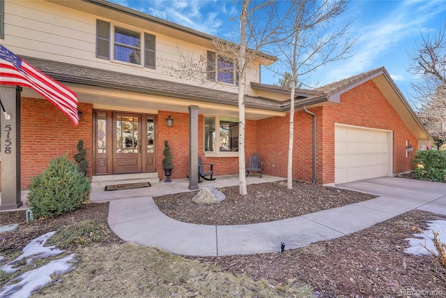 traditional-style house featuring covered porch, brick siding, driveway, and an attached garage