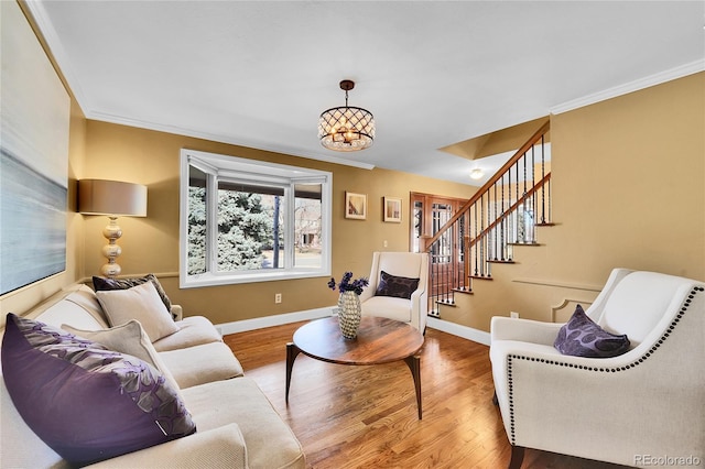 living room featuring baseboards, stairway, wood finished floors, and ornamental molding