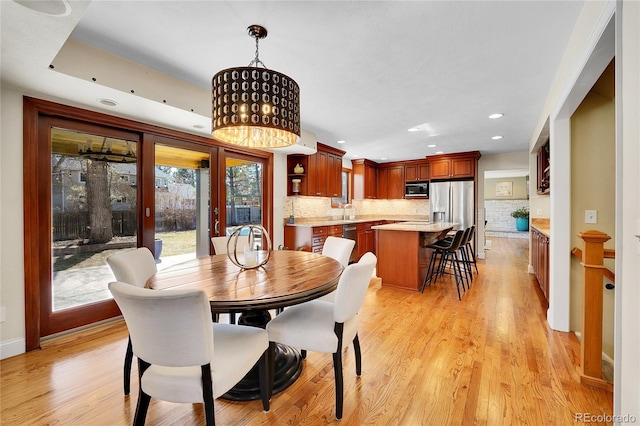 dining space featuring light wood-style floors, recessed lighting, french doors, and baseboards