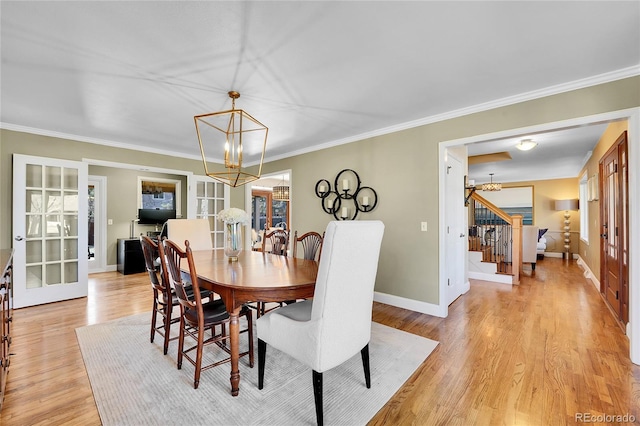 dining room with a chandelier, french doors, light wood-style flooring, and stairway