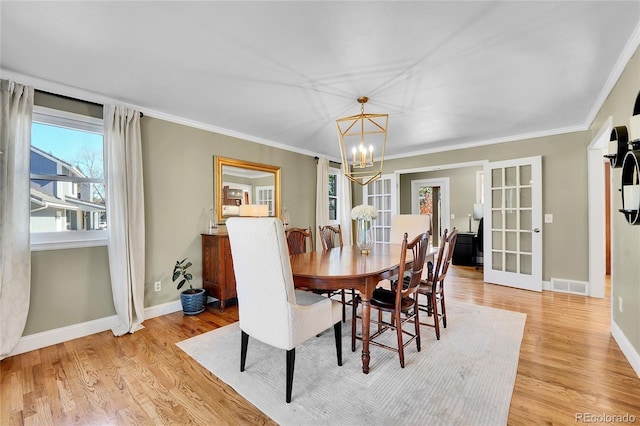 dining room featuring light wood-style floors, visible vents, a notable chandelier, and baseboards