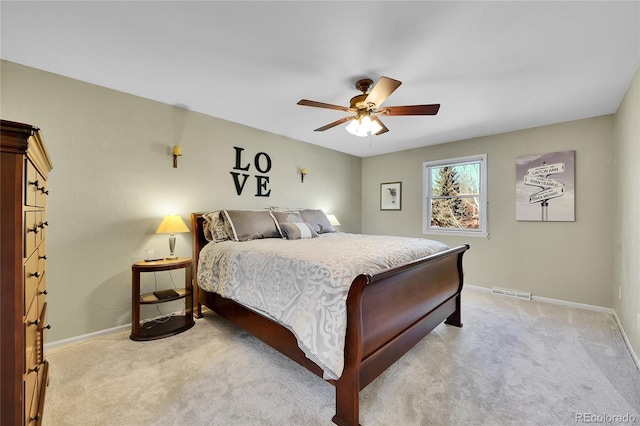 bedroom featuring light carpet, ceiling fan, visible vents, and baseboards