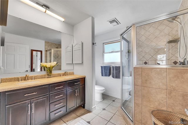 full bath with toilet, a shower stall, double vanity, and a sink