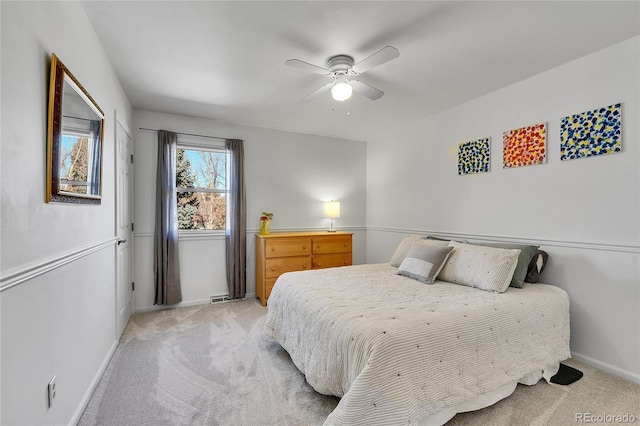 bedroom featuring light carpet, ceiling fan, and baseboards