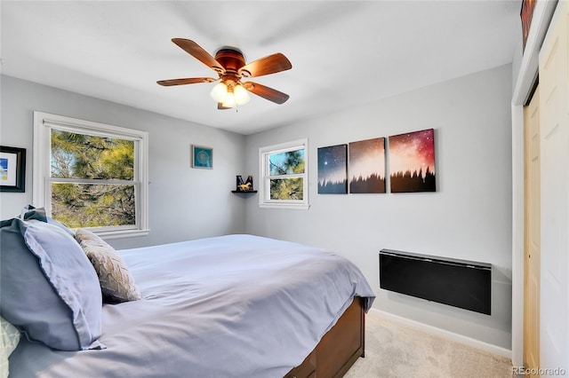 carpeted bedroom featuring a closet, ceiling fan, and baseboards