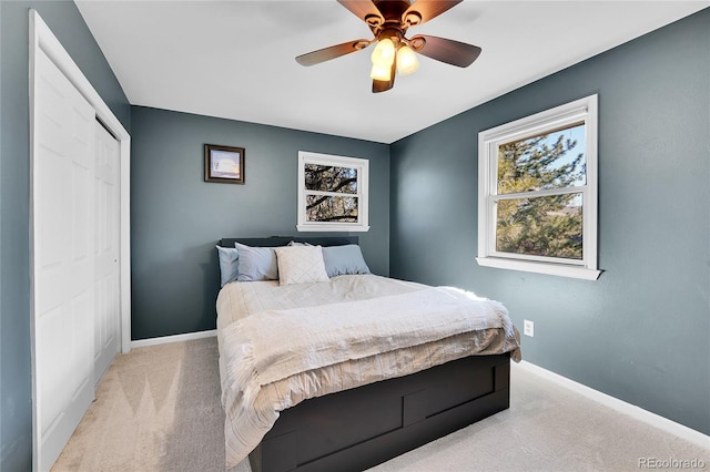 bedroom with multiple windows, baseboards, and light colored carpet