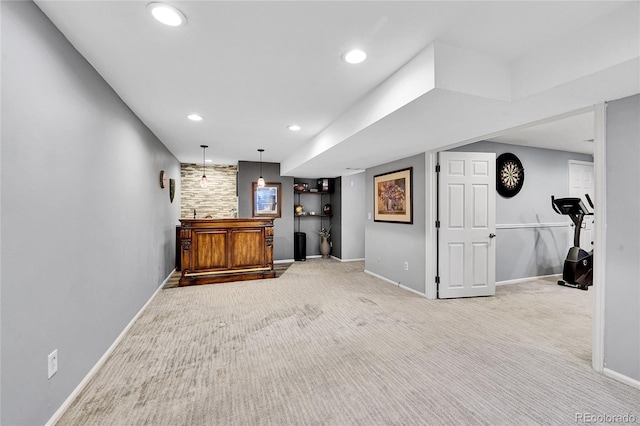 interior space featuring baseboards, light carpet, and a dry bar