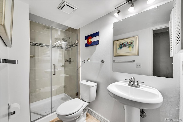 full bath with toilet, a stall shower, visible vents, and baseboards