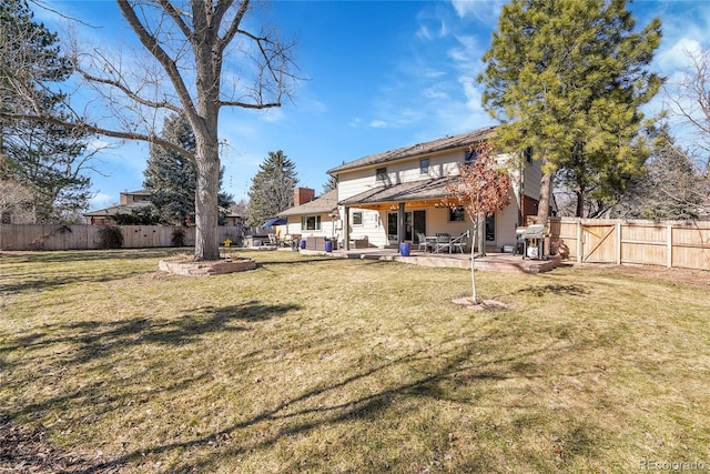 back of property featuring a fenced backyard, a yard, and a patio