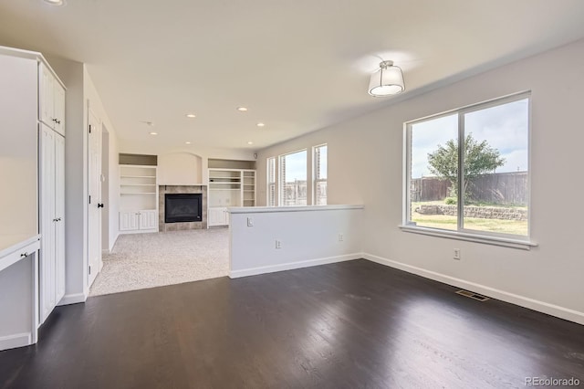 19033 E 22nd Cir, Aurora, CO 80011 - unfurnished living room with a tiled fireplace, built in shelves, wood finished floors, and recessed lighting