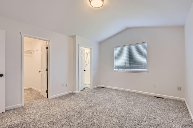 19033 E 22nd Cir, Aurora, CO 80011 - unfurnished bedroom featuring a walk in closet, carpet flooring, lofted ceiling, and a closet