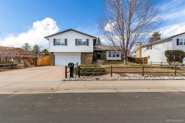 view of front facade featuring driveway, a fenced front yard, and a garage