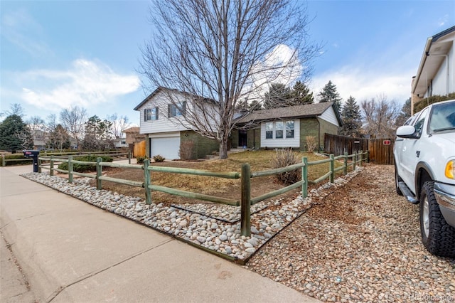 split level home with a fenced front yard and an attached garage