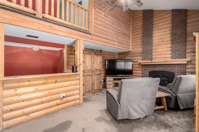 carpeted living area featuring a towering ceiling, a fireplace, visible vents, and a ceiling fan