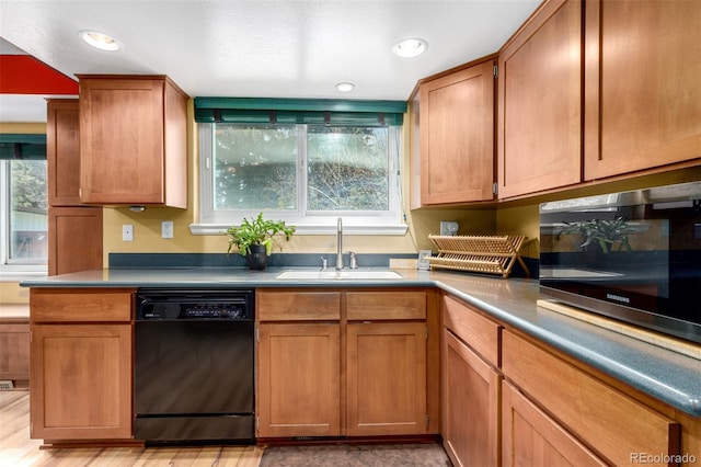 kitchen with a sink, stainless steel microwave, brown cabinetry, and dishwasher