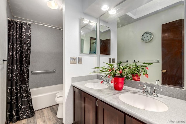 bathroom featuring a sink, shower / bathtub combination with curtain, toilet, and wood finished floors