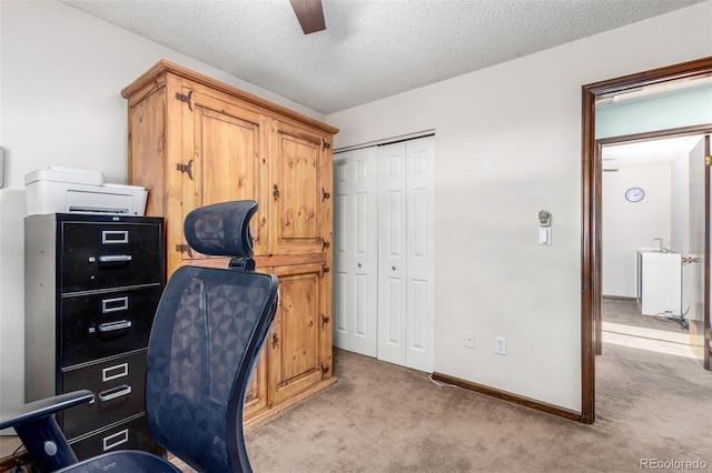 office area with light carpet, a textured ceiling, a ceiling fan, and baseboards