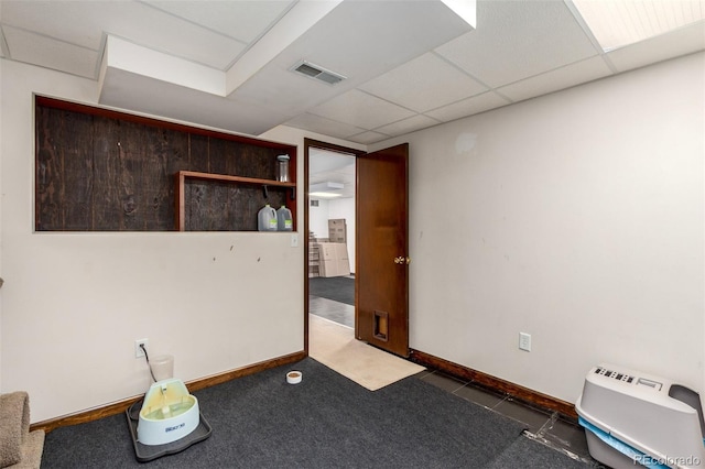 empty room with carpet, baseboards, visible vents, and a drop ceiling