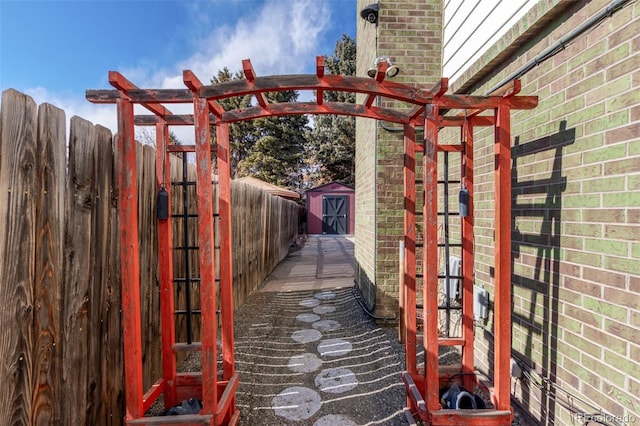 exterior space with an outbuilding, a storage unit, and fence