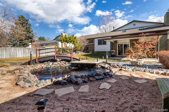 rear view of property with a patio, a chimney, and fence