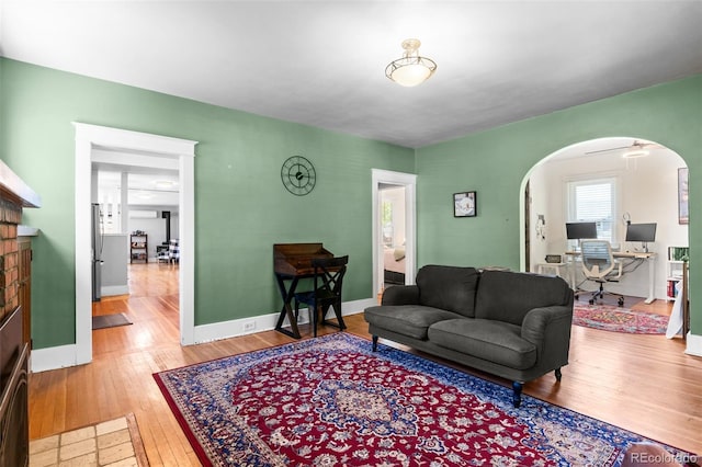 4321 Winona Ct, Denver, CO 80212 - living area with arched walkways, wood finished floors, a brick fireplace, and baseboards